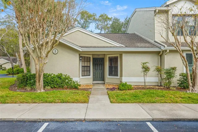 a front view of a house with a yard and potted plants