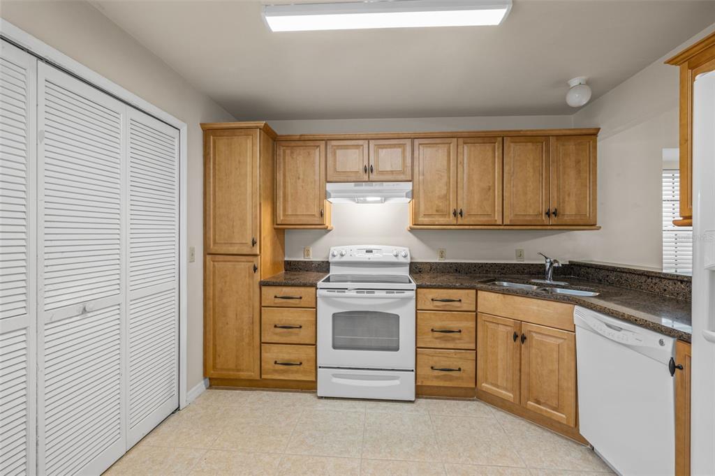 5100 Burchette Road, Unit 300 Tampa, FL 33647 - Photo 11 of 27 a kitchen with granite countertop white cabinets and white appliances