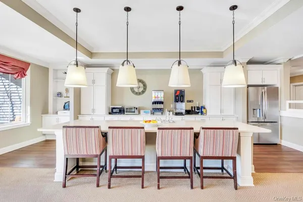 a kitchen with stainless steel appliances kitchen island granite countertop white cabinets and window