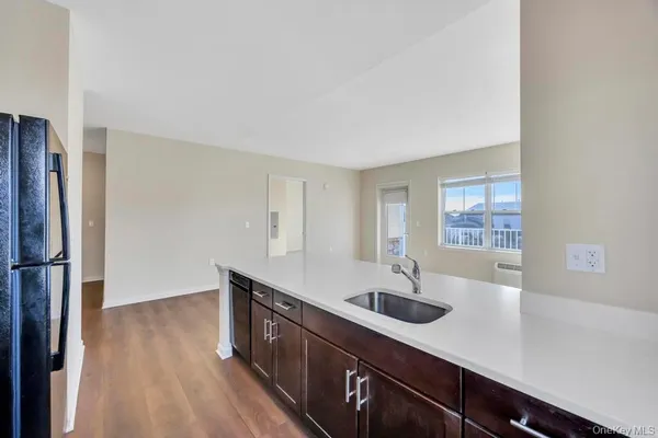 a kitchen with stainless steel appliances a sink a refrigerator and wooden floor