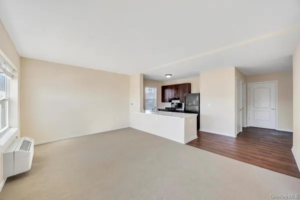 a view of kitchen with refrigerator stove and wooden floor