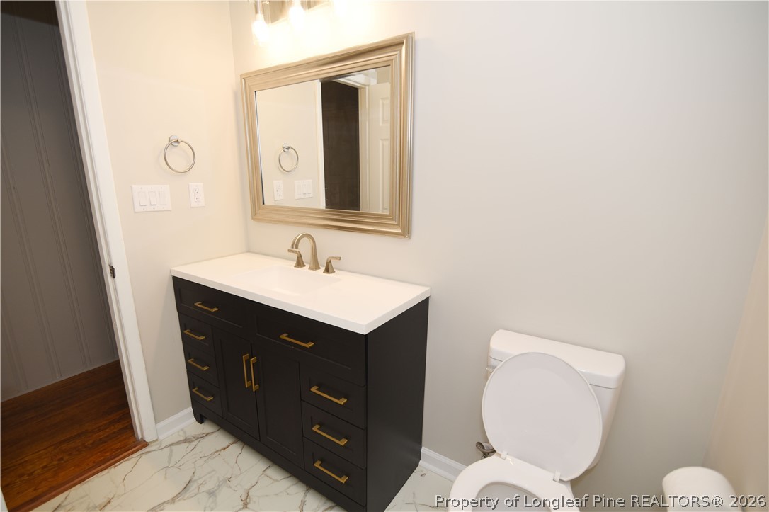 1673 Norment Road Lumberton, NC 28360 - Photo 27 of 32 a bathroom with a toilet sink and mirror