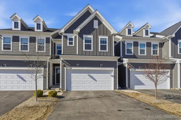 a front view of a house with yard and parking