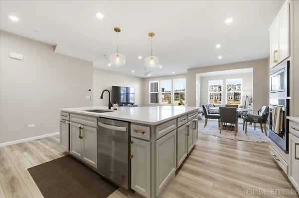 a large kitchen with stainless steel appliances granite countertop a lot of counter space and wooden floor