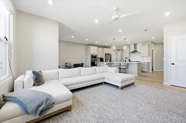 a living room with furniture and a view of kitchen