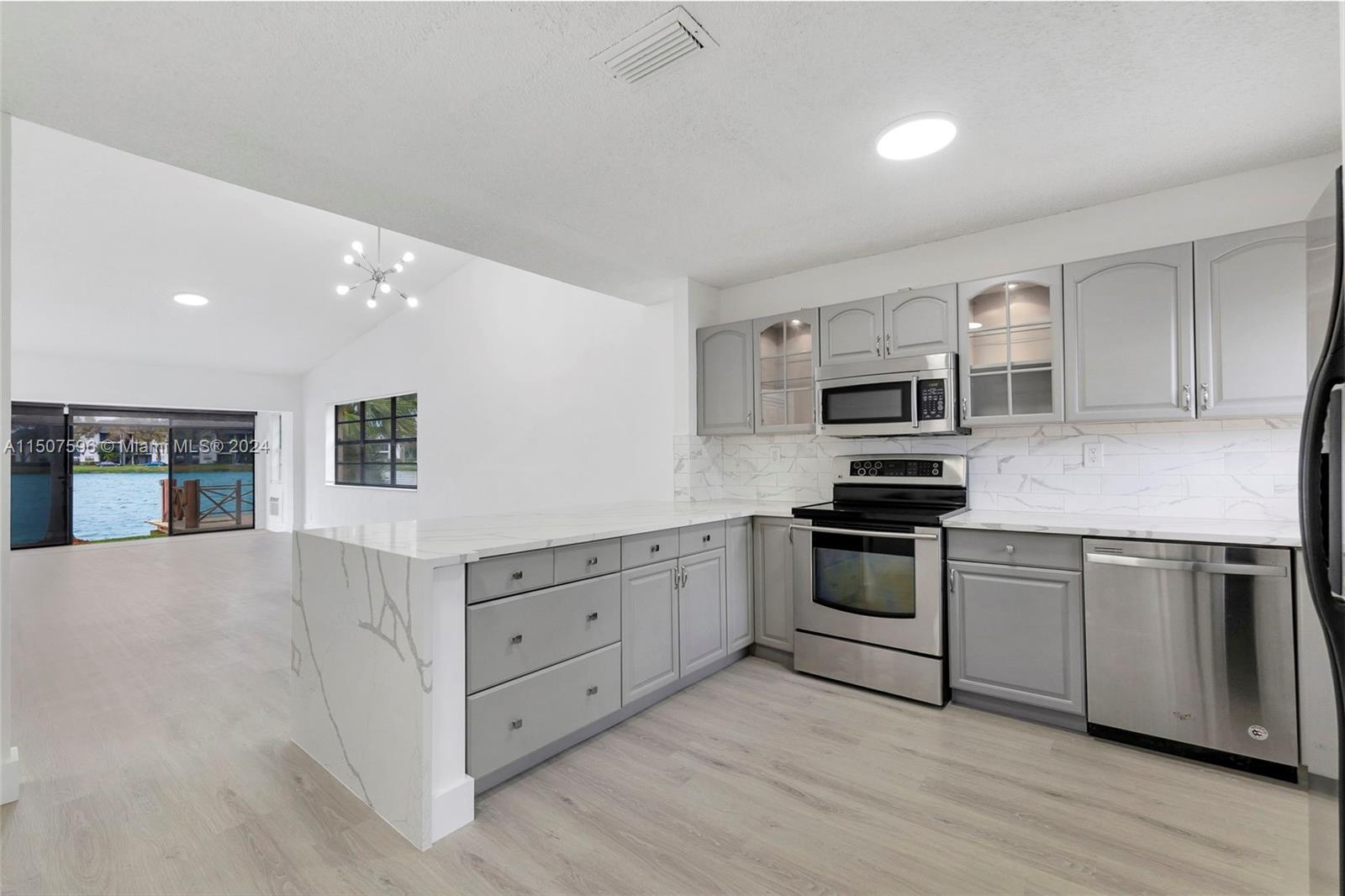 645 Banks Road Margate, FL 33063 - Photo 15 of 38 a kitchen with stainless steel appliances granite countertop a stove top oven a sink dishwasher and a refrigerator with wooden floor