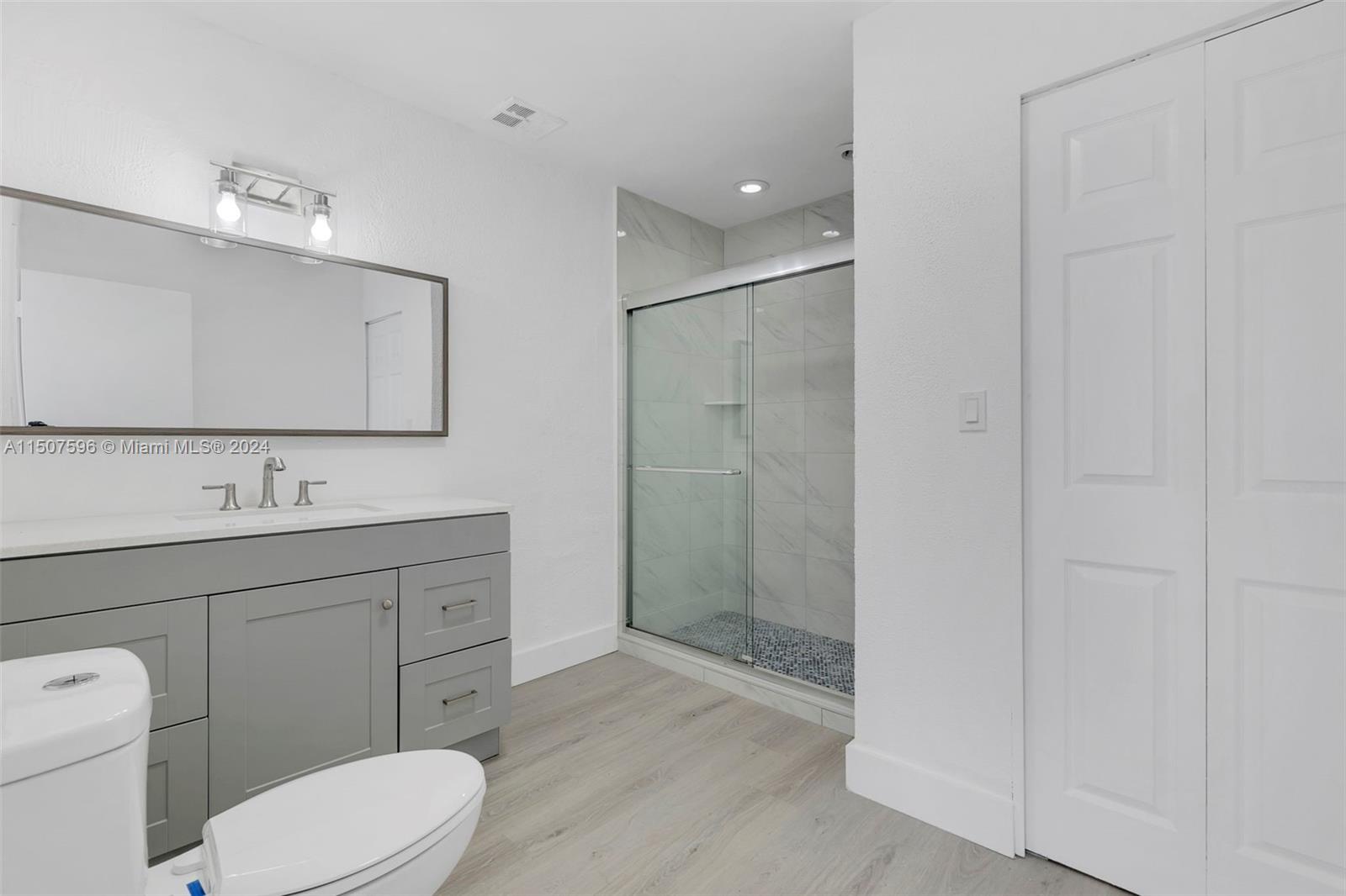 645 Banks Road Margate, FL 33063 - Photo 21 of 38 a bathroom with a toilet a sink shower and mirror
