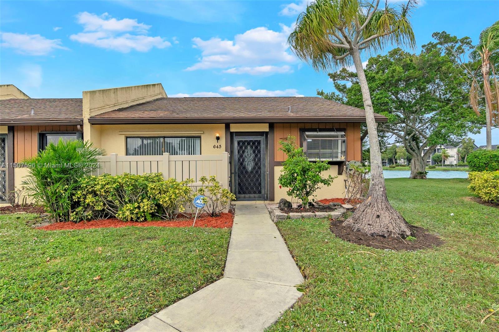 645 Banks Road Margate, FL 33063 - Photo 3 of 38 a front view of a house with a yard and potted plants