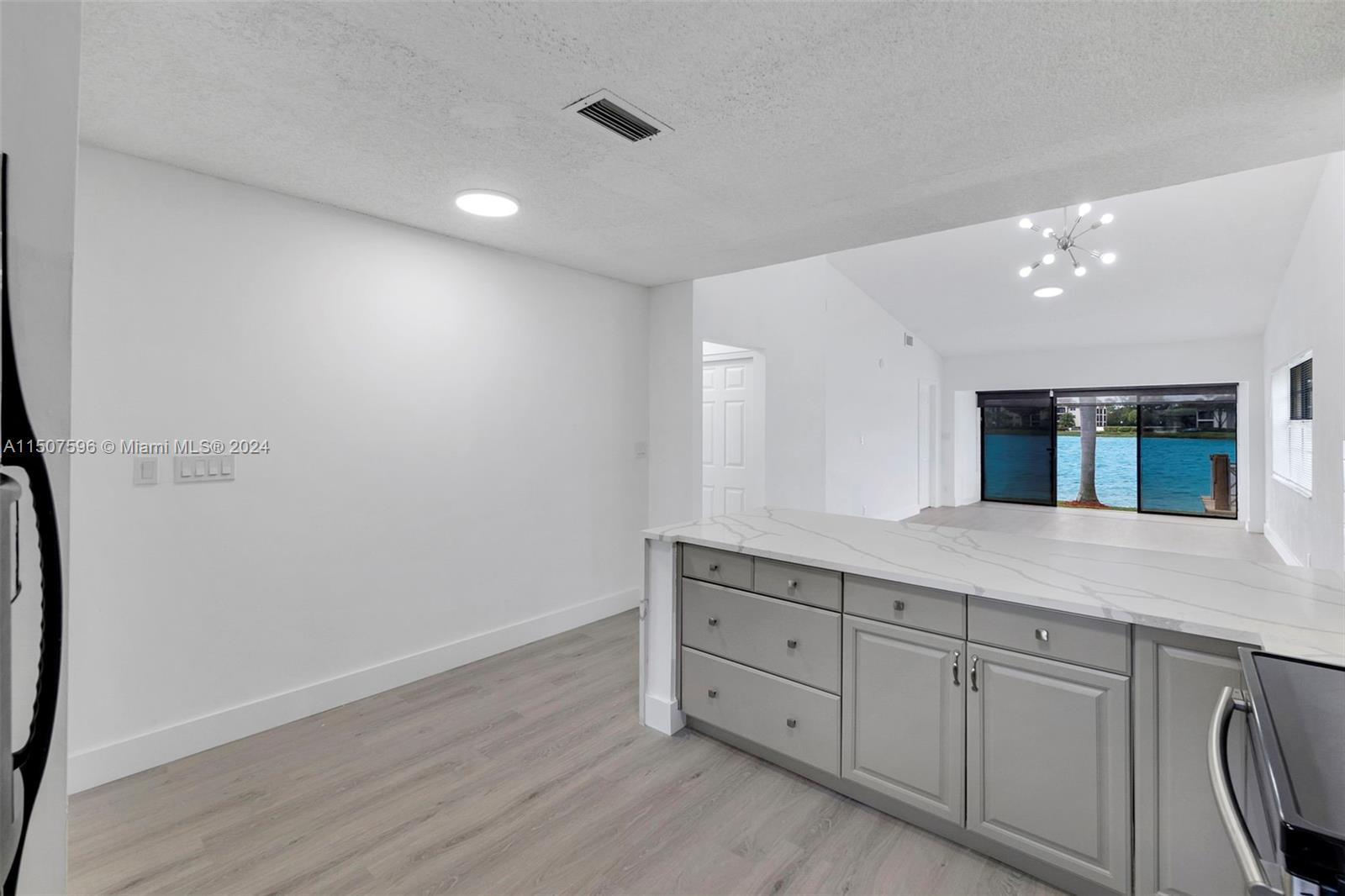 645 Banks Road Margate, FL 33063 - Photo 7 of 38 a hall with cabinets and wooden floor
