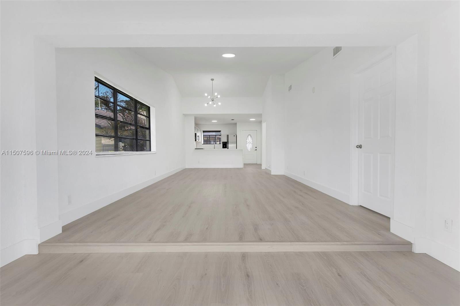 645 Banks Road Margate, FL 33063 - Photo 8 of 38 an empty room with wooden floor and windows