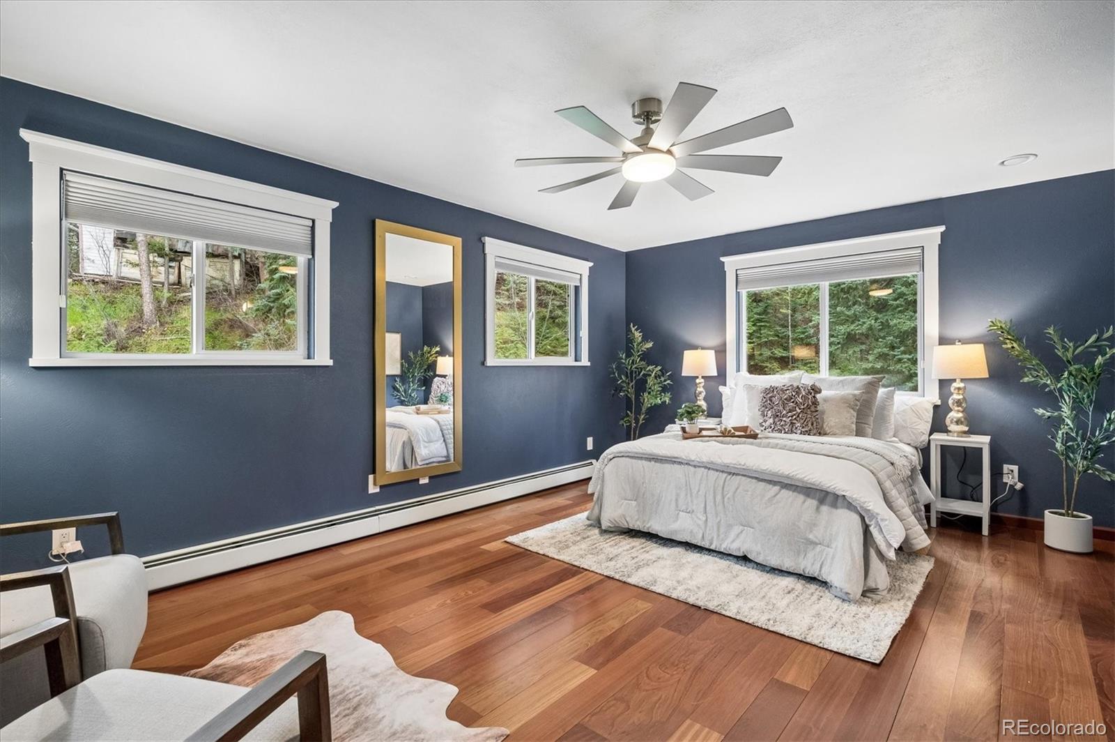 6747 South Brook Forest Road Evergreen, CO 80439 - Photo 20 of 49 a spacious bedroom with a large bed and a window