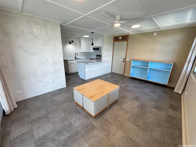 a living room with stainless steel appliances kitchen island granite countertop a sink and cabinets
