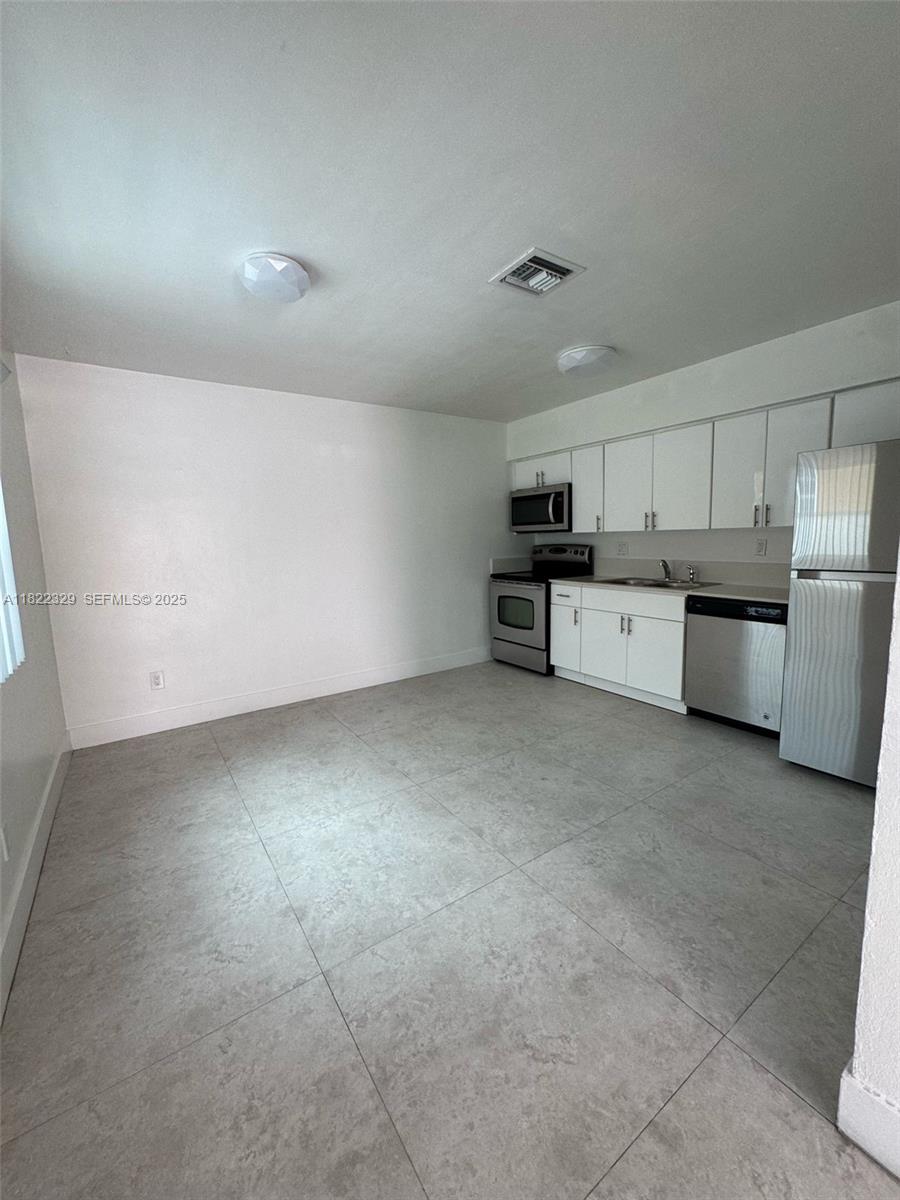 2941 Southwest 36th Avenue, Unit A Miami, FL 33133 - Photo 12 of 23 a view of a kitchen with refrigerator stove and microwave