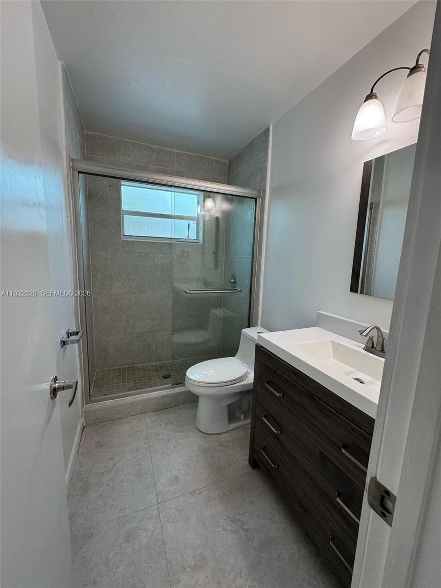 2941 Southwest 36th Avenue, Unit A Miami, FL 33133 - Photo 14 of 21 a bathroom with a toilet a sink a shower and mirror