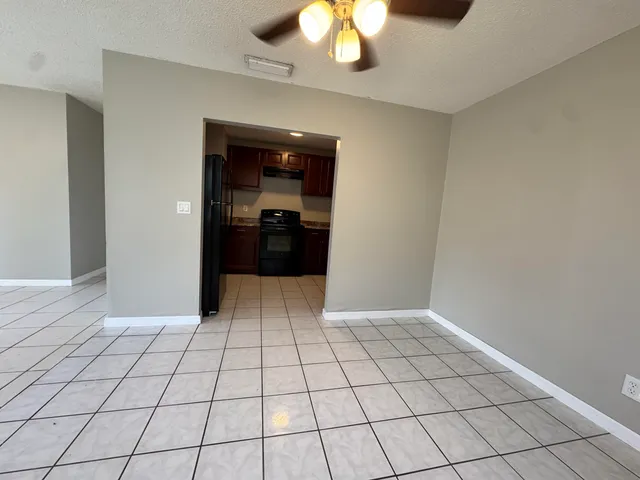 a view of an empty room and a chandelier fan
