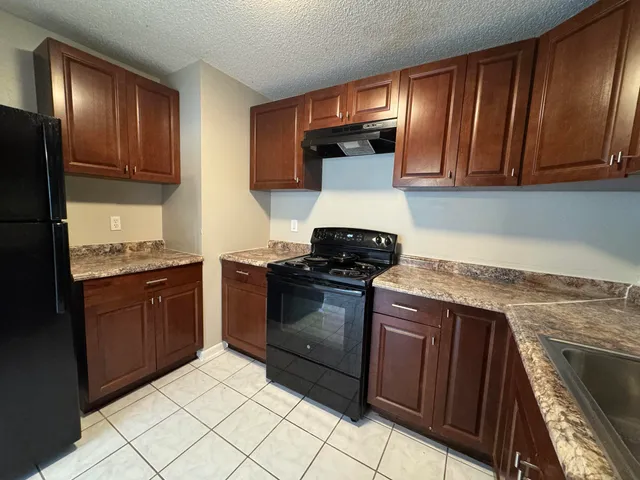 a kitchen with a stove top oven and cabinets