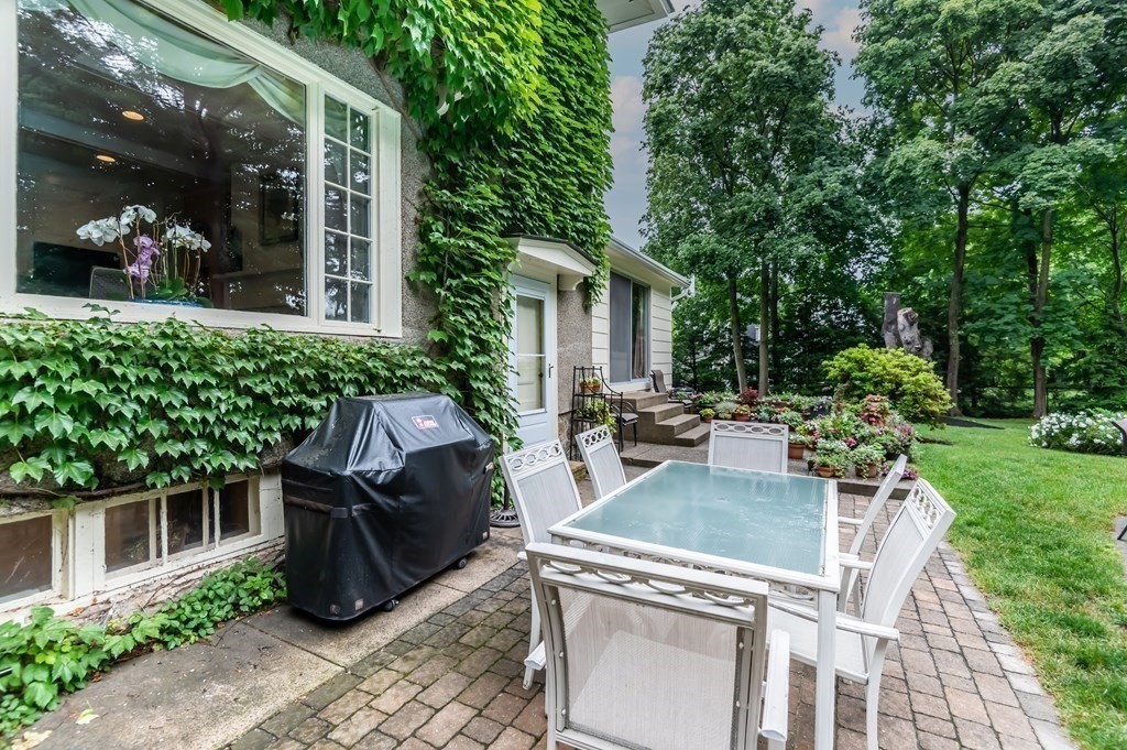 16 Hidden Road Andover, MA 01810 - Photo 34 of 42 a view of a patio with table and chairs potted plants and floor to ceiling window