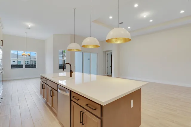 a kitchen with a sink a counter space and a chandelier