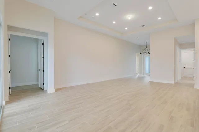 an empty room with wooden floor and natural light
