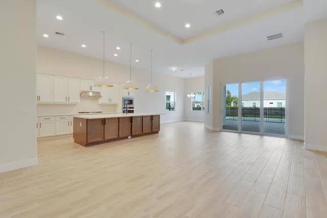 a large kitchen with stainless steel appliances granite countertop a large counter top and a wooden floors