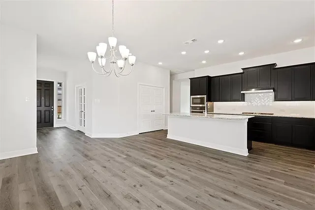 a view of kitchen with granite countertop cabinets and refrigerator