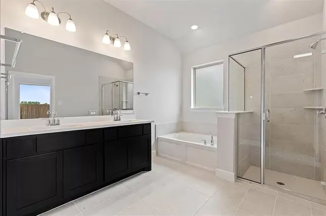 a spacious bathroom with a tub sink shower and mirror