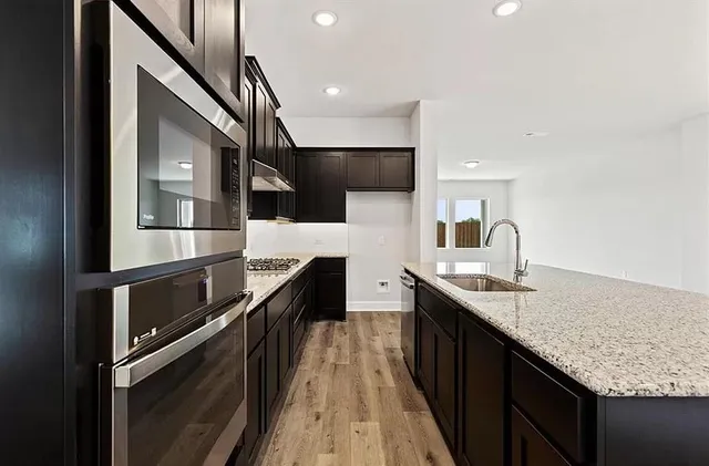 a kitchen with granite countertop stainless steel appliances and sink