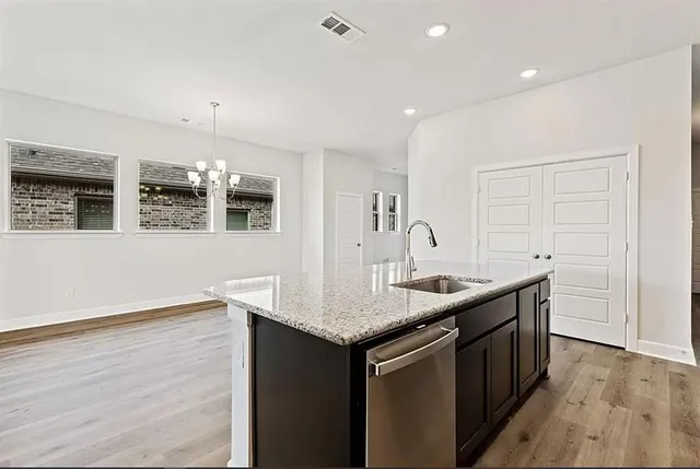 a kitchen with granite countertop kitchen island a sink and a stove