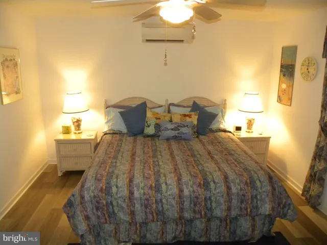 a bed sitting in a bedroom and lamp next to a window with a bathroom