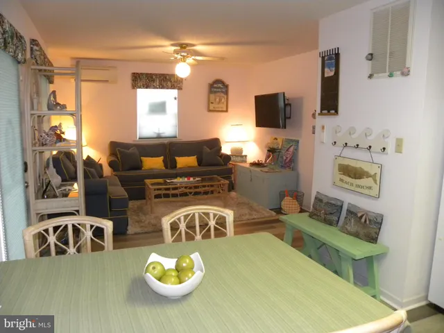 a living room with furniture a flat screen tv and a table