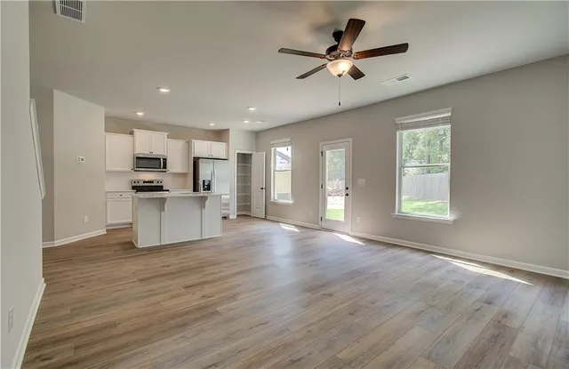 a view of kitchen with sink microwave refrigerator and cabinets