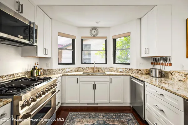 a kitchen with a stove a sink and a microwave