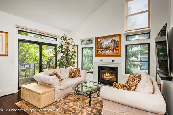 a living room with furniture large window and a fireplace