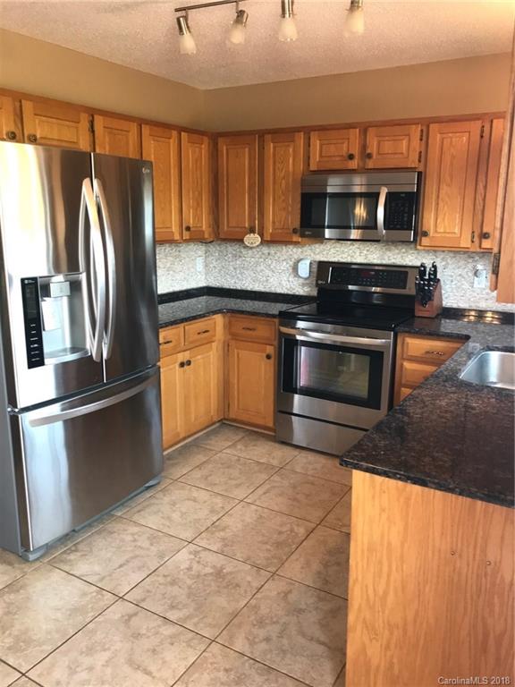 4741 Kemp Dellinger Road Maiden, NC 28650 - Photo 6 of 21 a kitchen with granite countertop a refrigerator and a stove top oven