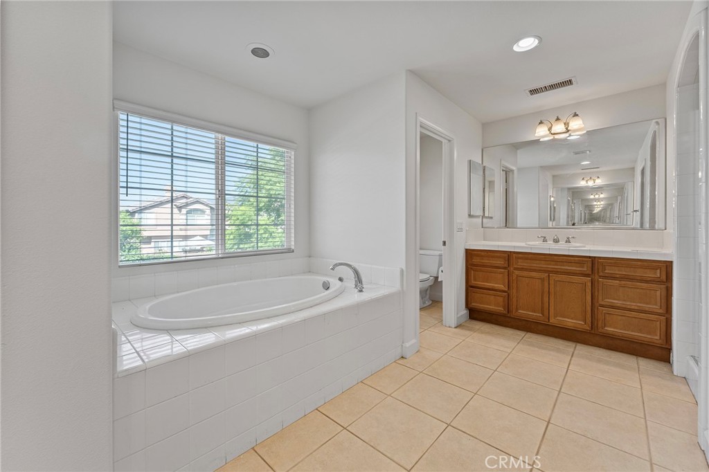 6360 Day Lily Court Rancho Cucamonga, CA 91737 - Photo 33 of 56 a spacious bathroom with a tub sink shower and mirror