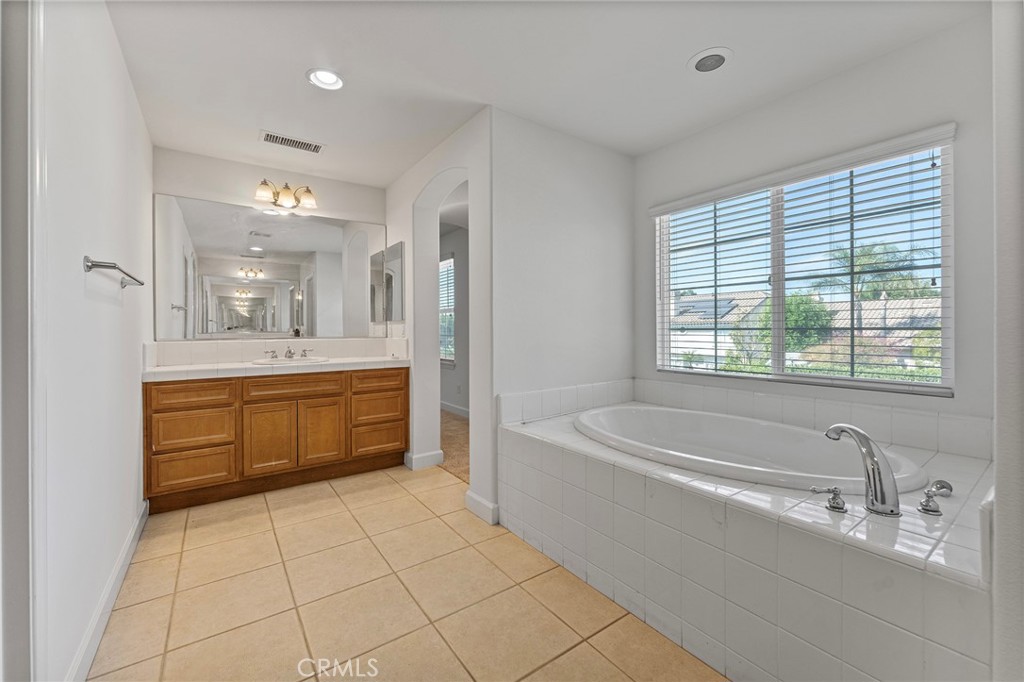 6360 Day Lily Court Rancho Cucamonga, CA 91737 - Photo 34 of 56 a bathroom with a tub a sink a mirror and a bathtub