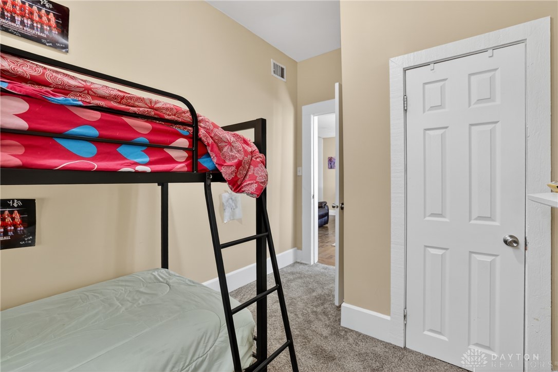 7045-7049 Montgomery Road Cincinnati, OH 45236 - Photo 54 of 68 This cozy bedroom offers a perfect blend of comfort and simplicity, featuring soft carpeting and a classic door.