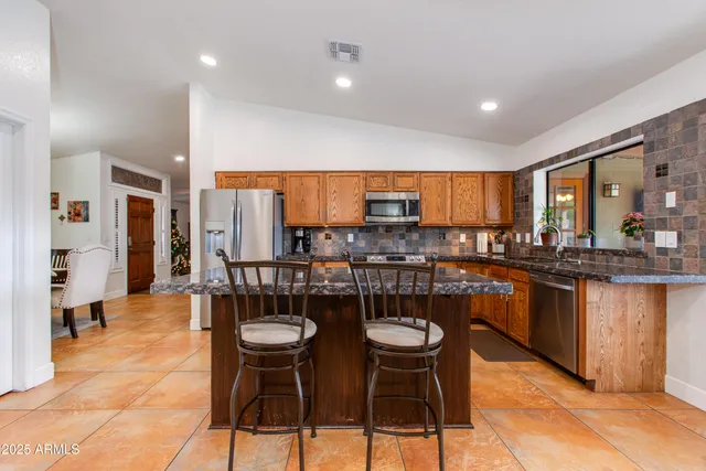 a kitchen with stainless steel appliances kitchen island granite countertop a sink and cabinets