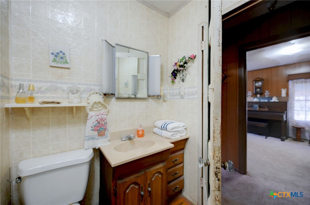 1631 East Fannin Street Luling, TX 78648 - Photo 22 of 27 a bathroom with a sink and a mirror