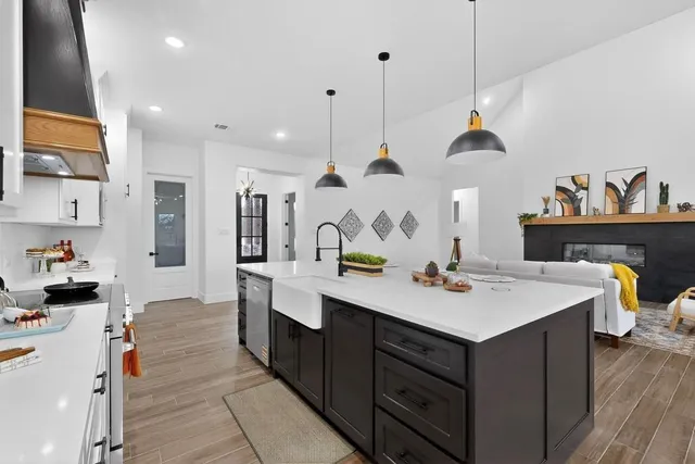 a view of kitchen island a sink wooden floor and living room view