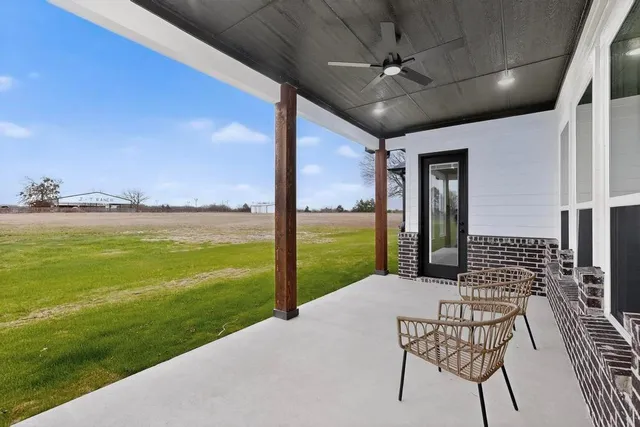 a view of a porch with furniture and garden