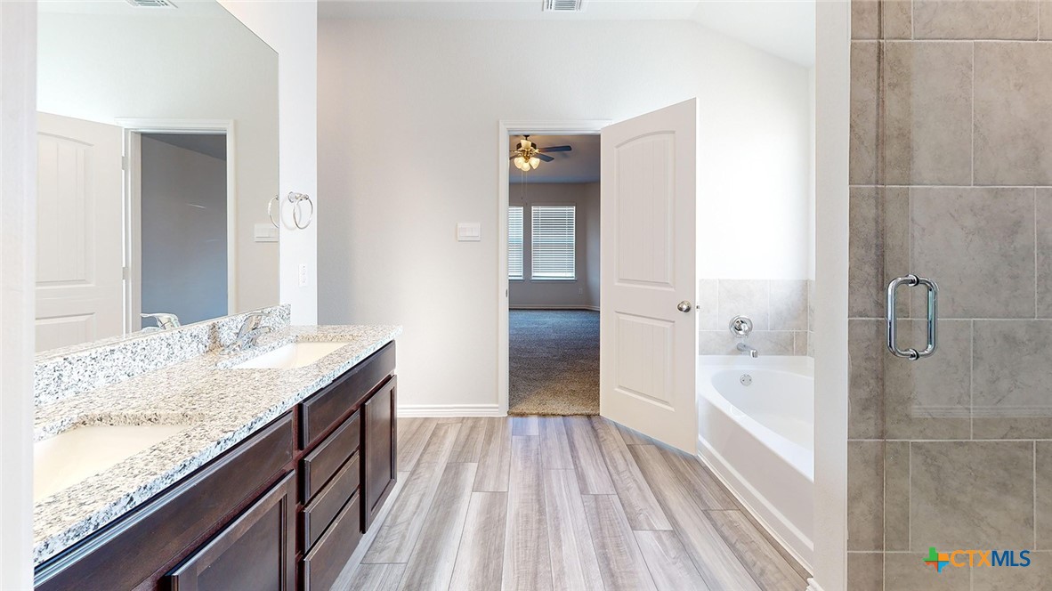 2136 Buckner Street Nolanville, TX 76559 - Photo 22 of 33 a bathroom with a granite countertop sink a toilet and shower