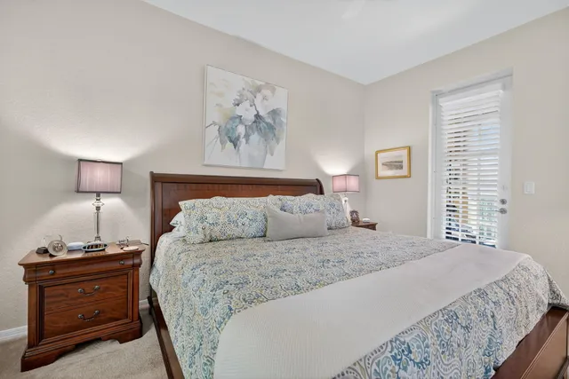 a bedroom with a bed and a lamp on dresser