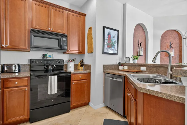 a kitchen with stainless steel appliances granite countertop a stove a sink and a microwave