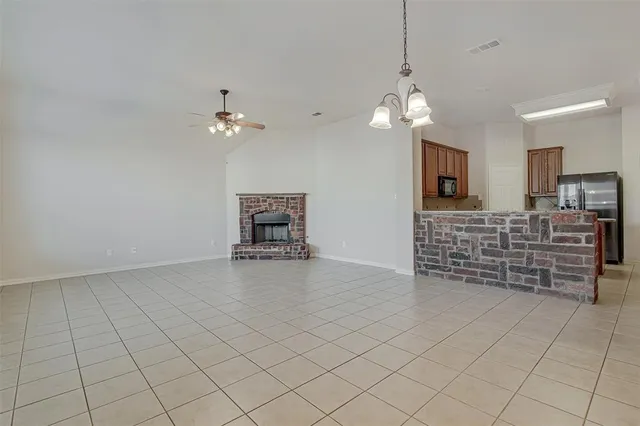 an empty room with chandelier fan
