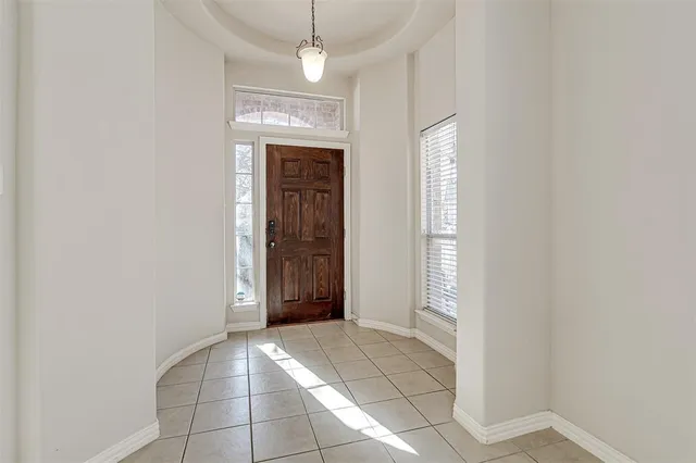 an empty room with windows and chandelier