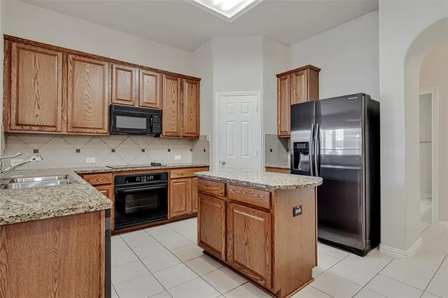 a kitchen with stainless steel appliances granite countertop a stove refrigerator sink and microwave
