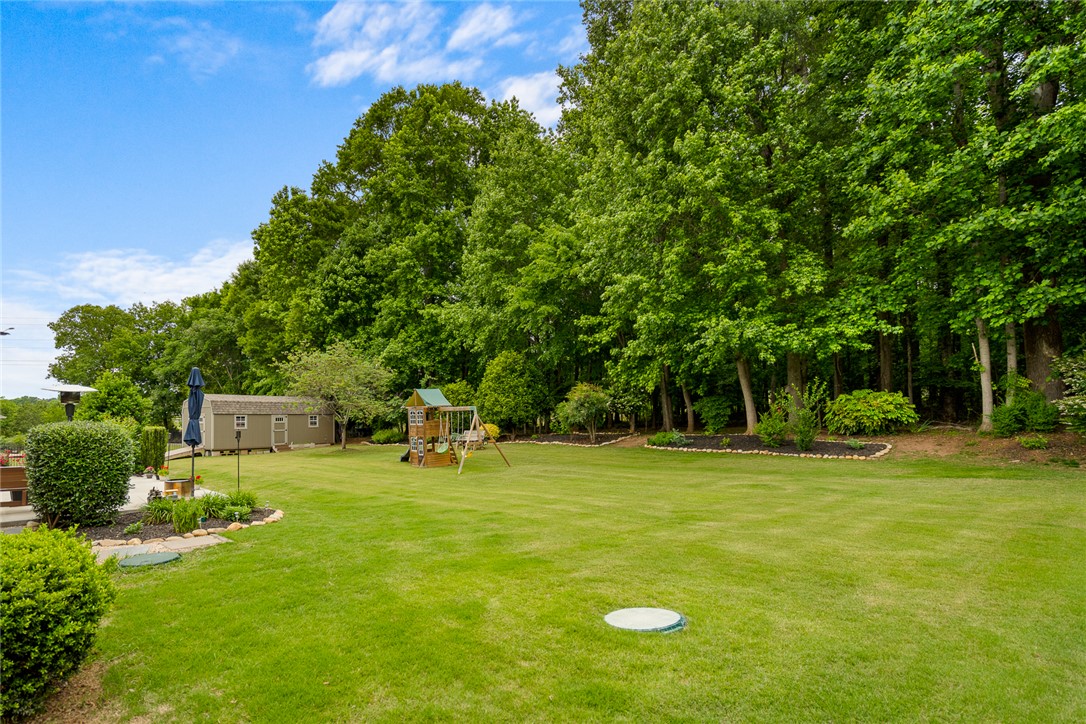 128 Baybrooke Lane Anderson, SC 29621 - Photo 33 of 37 A spacious, verdant yard with mature trees providing a natural boundary.
