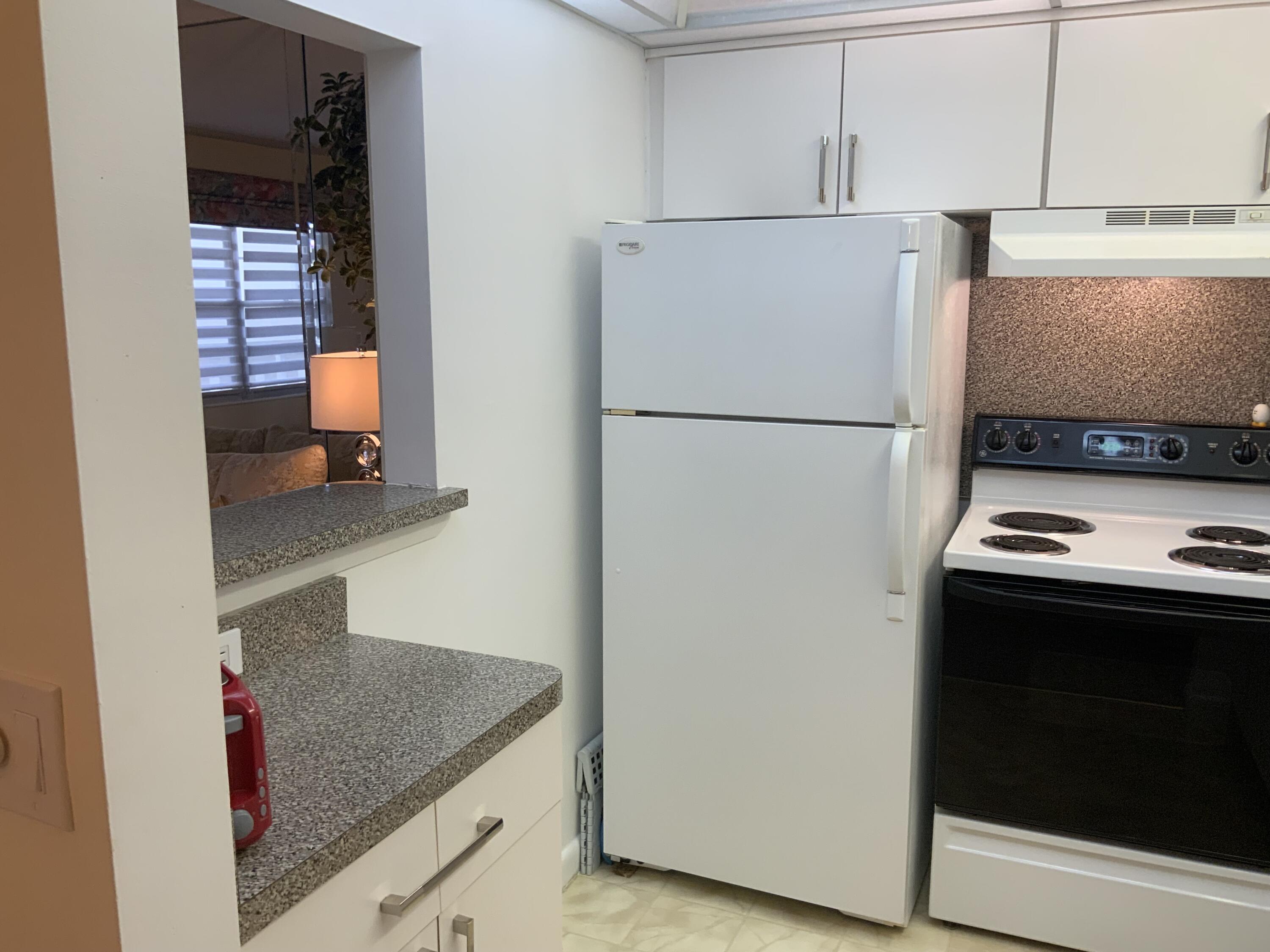 353 Dorset I Boca Raton, FL 33434 - Photo 8 of 30 a white refrigerator freezer and a stove sitting inside of a kitchen