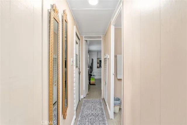 a view of a hallway with wooden floor and a bathroom